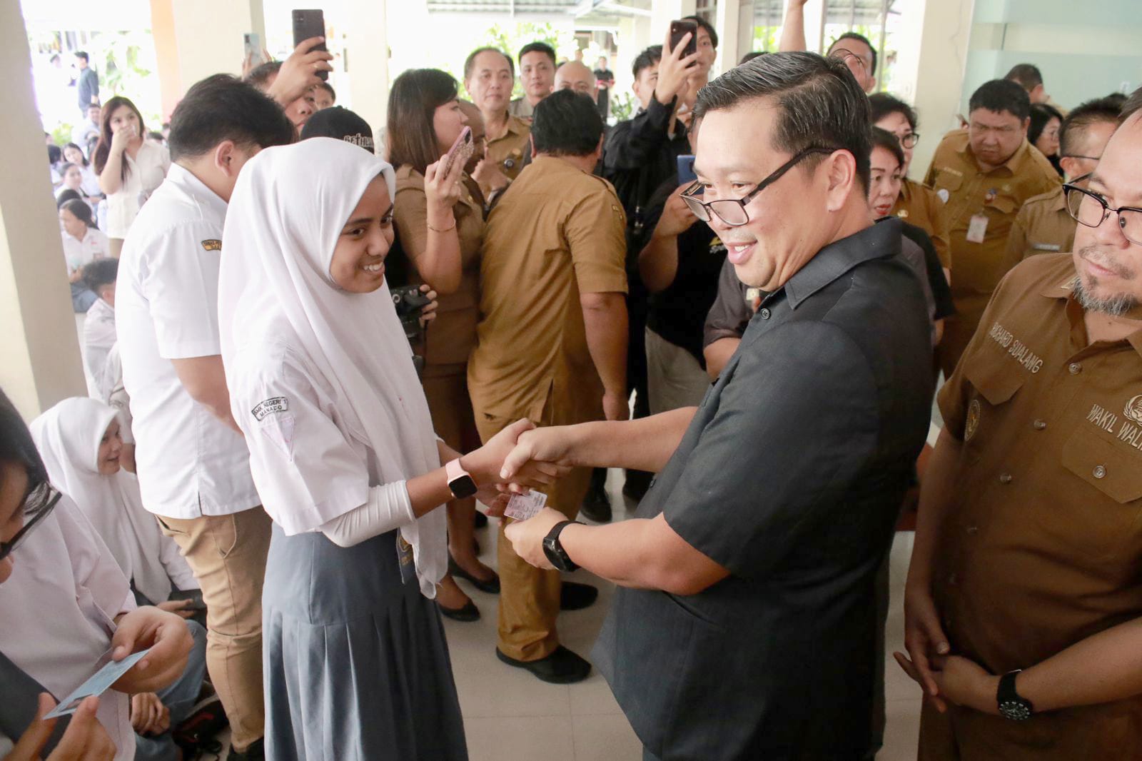 Wakil Gubernur Sulawesi Utara (Sulut) Steven Kandouw saat memberikan KTP gratis kepada salah satu siswi di SMK Negeri 1 Manado, Selasa (10/10/2023). (Foto: DKIPS)